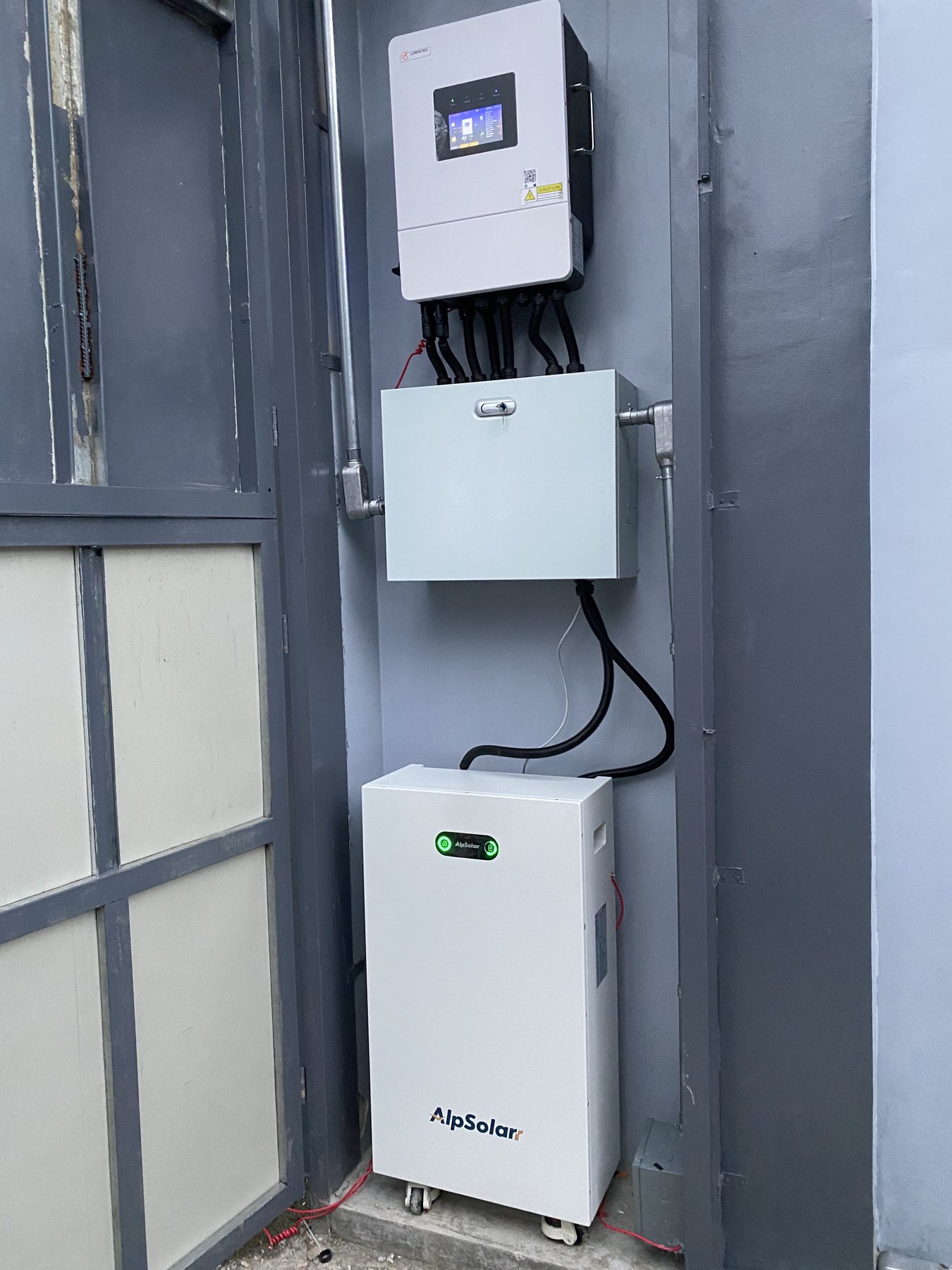 Inverter and battery unit mounted on a grey wall