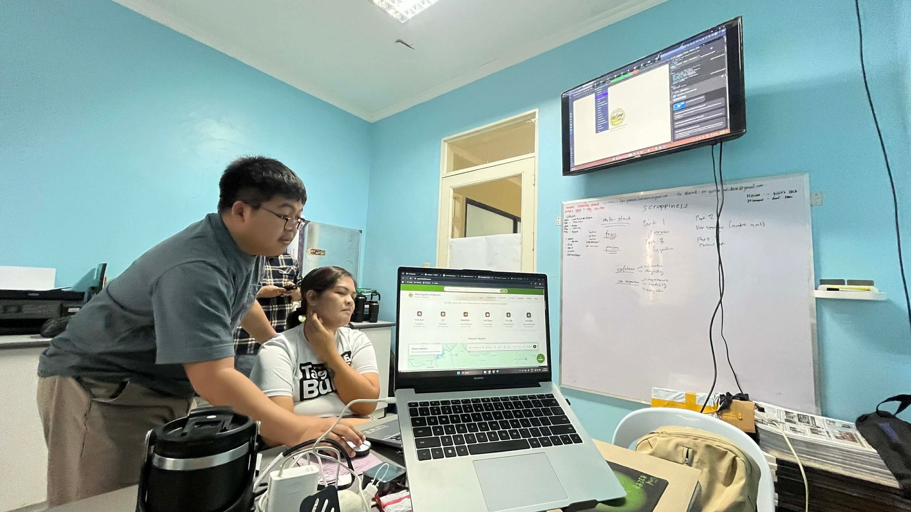 Haturiko and LGU staff reviewing the website on a laptop