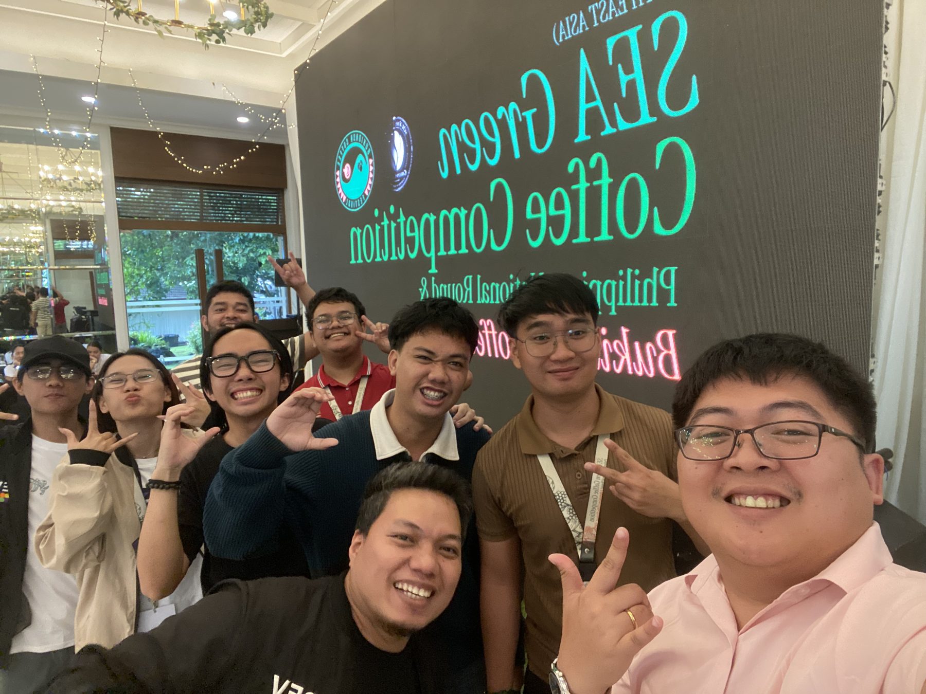 Team group photo in front of the Sea Green Coffee Competition sign